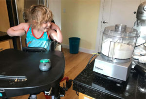 Little girl using a wireless switch to activate a food processor.